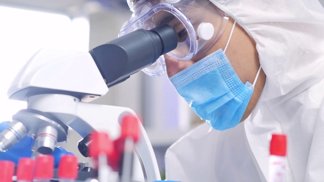 领导亚洲男性科学家信心戴着防护面罩和套装看显微镜聚焦从病毒到实验室技术研究冠状病毒或Covid-19。科学技术，医学概念。视频素材
