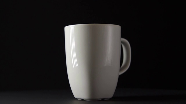 黑色背景上的白色陶瓷杯转动手柄视频下载