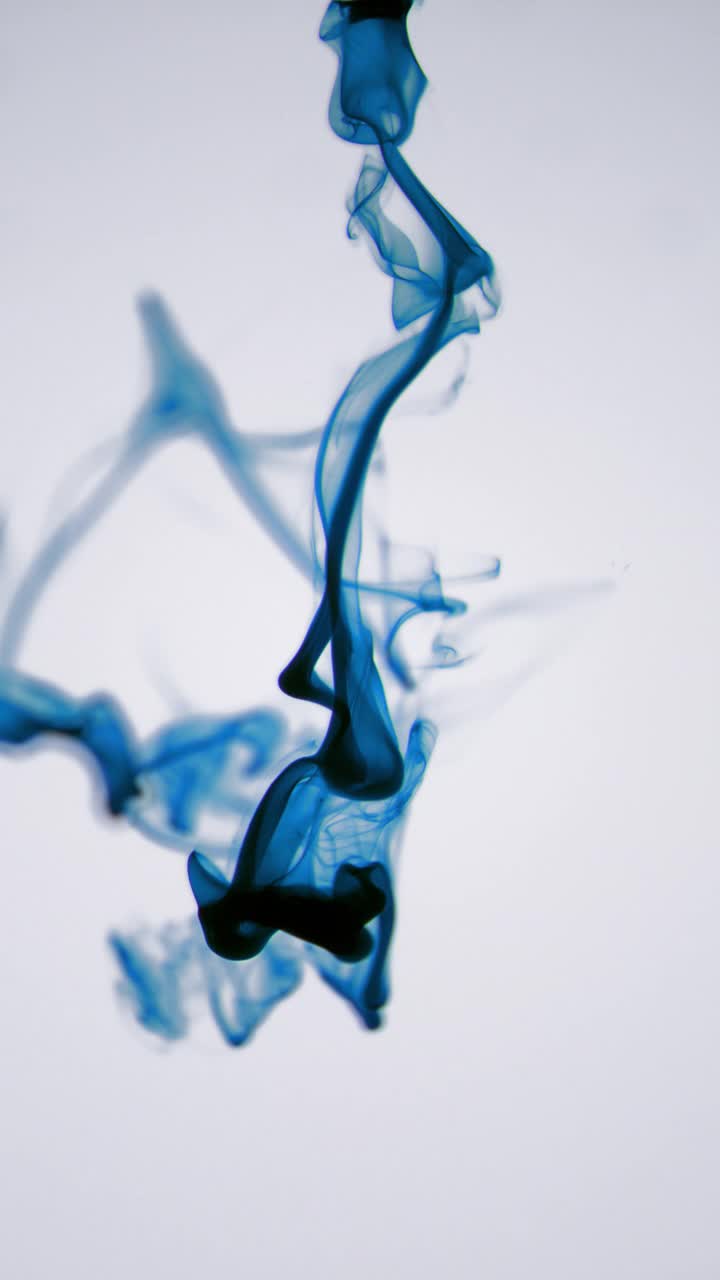 孤立的蓝色墨水云在宏观慢动作的白色背景框架垂直视频视频素材