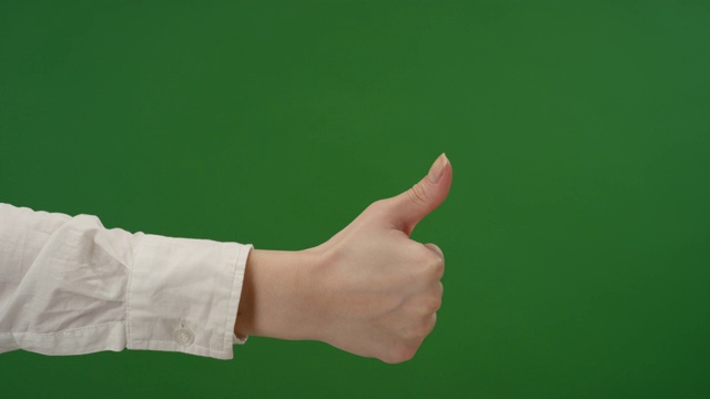 女性的手在绿色屏幕上竖起大拇指视频下载