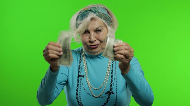 年迈的祖母。白人妇女拿着钞票微笑着庆祝视频下载