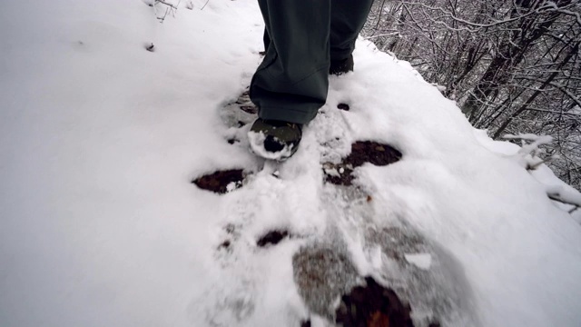 一名男子在积雪覆盖的山上的小路上徒步旅行视频素材