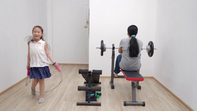 在covid-19病毒大流行期间，母亲和女儿正在家中锻炼视频素材