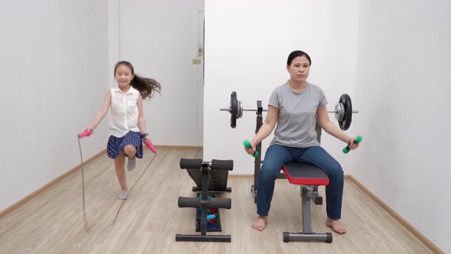 在covid-19病毒大流行期间，母亲和女儿正在家中锻炼视频素材