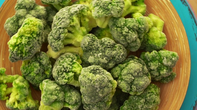 冷冻西兰花。绿花椰菜背景加冰和霜。冷冻蔬菜视频素材