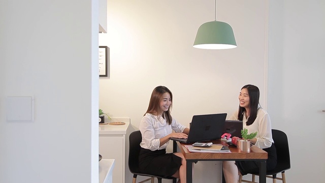 亚洲华人女性在家里一边用笔记本电脑工作一边聊天视频素材