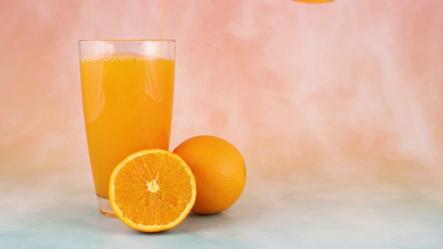 将鲜榨的橙汁倒入玻璃杯中视频素材