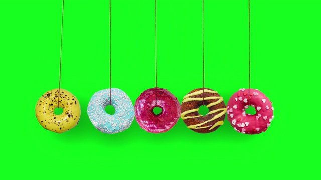 彩色的甜甜圈摆动作为一个牛顿的摇篮在色度键的背景视频下载