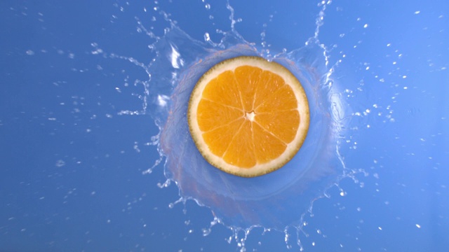 一片橘子掉进了蓝色的水里视频素材