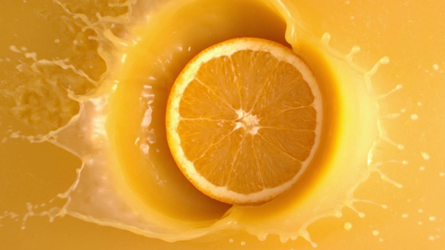 在慢镜头中，一片橙子变成了果汁视频素材
