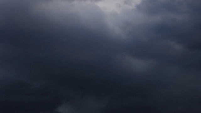 随着时间的推移，黑色的雨云在白天的天空中快速移动。视频素材