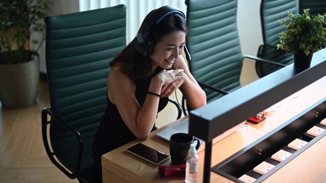 一位亚洲华裔美丽的女白领戴着口罩对着摄像机进行视频通话，与他的商业伙伴进行视频会议视频素材