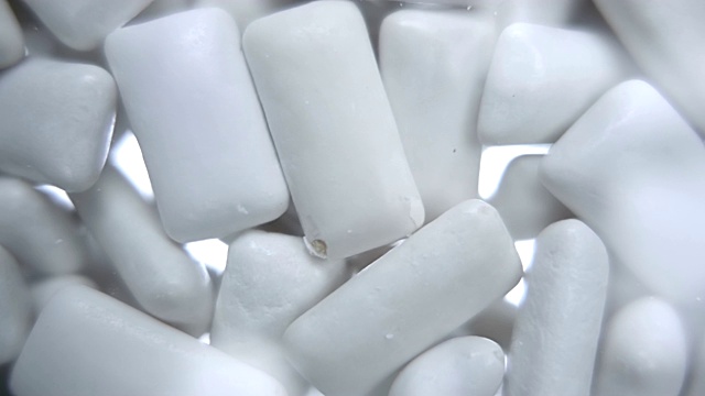 一堆白色的口香糖垫落在透明的表面上视频下载
