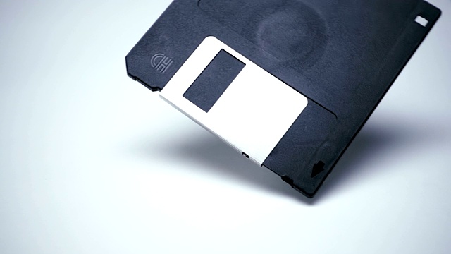 老式的黑色软盘落在白色表面上视频素材