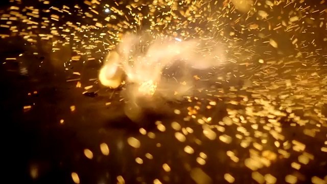 强烈的爆炸伴随着明亮的闪光和周围许多火花的散射视频素材