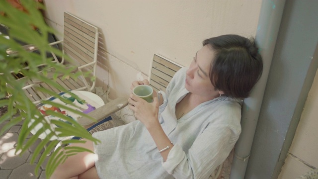 女孩喝咖啡或茶，享受坐在家里。早上第一件事就是去做。视频素材