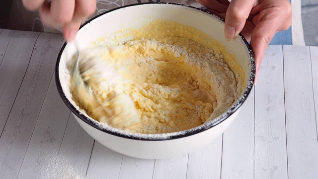 砂锅派用干酪面团的准备。厨师把面粉和白软干酪和鸡蛋倒进碗里。混合面团。视频素材