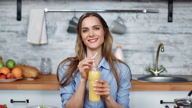 快乐女性饮料柑橘饮料在烹饪室内。由RED Raven 4k电影摄像机拍摄视频素材