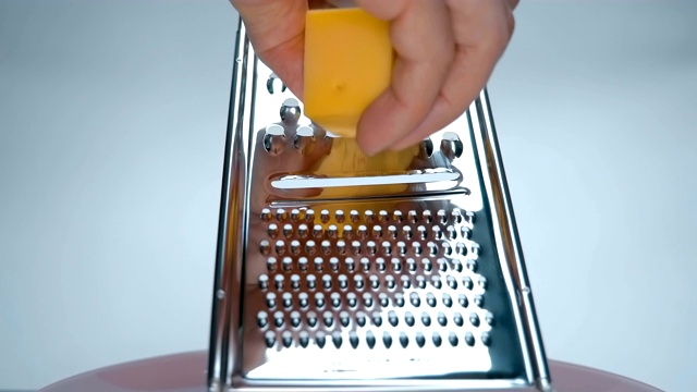 厨师用一个漂亮的磨碎器擦硬奶酪，以便进一步添加到沙拉中视频素材