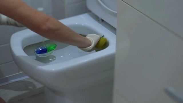 戴着白手套的年轻女子在洗马桶视频素材
