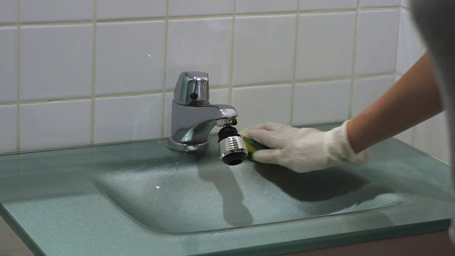 特写家庭主妇的手与手套清洁水槽视频下载