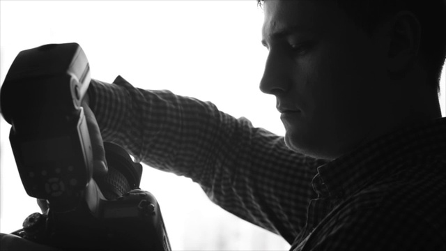 男摄影师取下专业相机的镜头视频下载