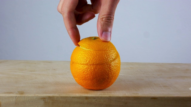用手在木板上削橘子很容易。4 k超高清。皮肤护理的概念。视频下载