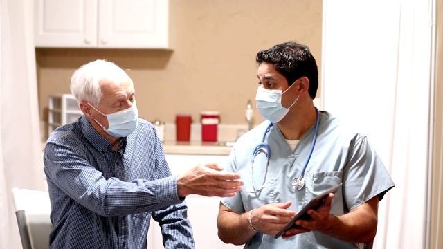 COVID-19:拉丁裔医生和老年患者，口罩。视频下载