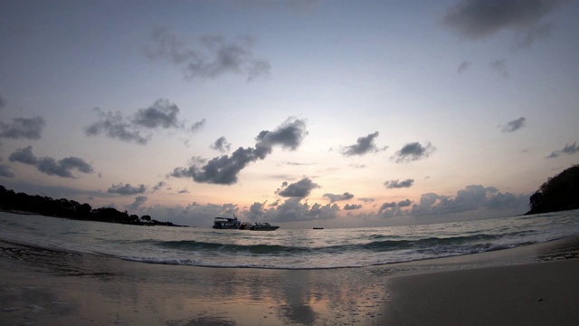 时间流逝的运动，海浪击中海滩和船背景云移动快，金色的光日出在早晨的天空视频素材