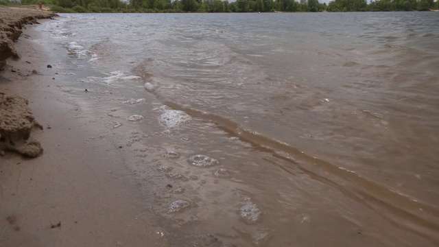 河岸用石头和浪花从较低的角度透视。视频下载