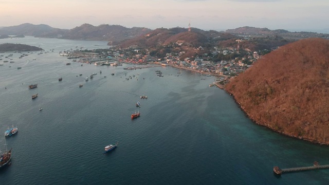 日落时分，无人机拍摄的海滩和港口。船只和码头，平静的海洋和岛屿，纳闽巴霍印度尼西亚视频素材