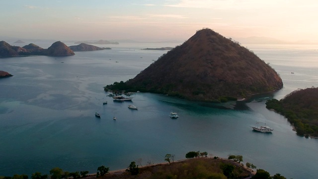 日落时分，无人机拍摄的海滩和港口。船只和码头，平静的海洋和岛屿，纳闽巴霍印度尼西亚视频素材