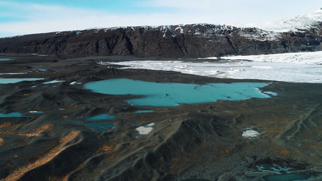 航拍移动摄影机拍摄冰岛冰川底部的融水湖视频素材