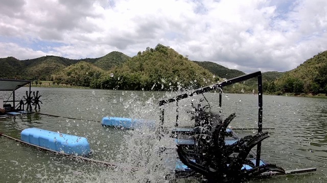 水轮机是一种工作轮转，造成了氧水疗法在水库背景下的山和天空中的云。视频下载