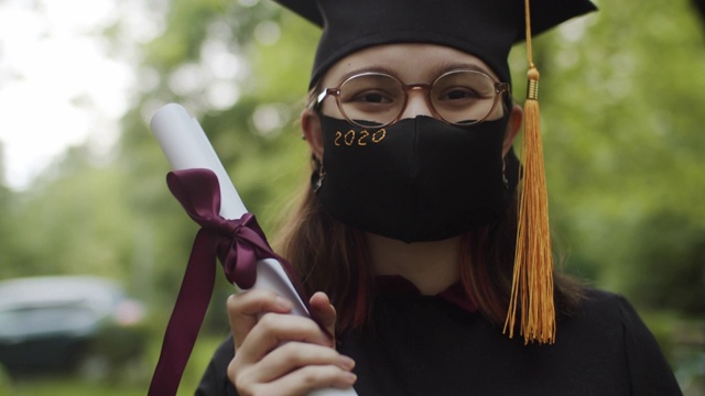 穿着毕业礼服、帽子和防护面具的少女视频下载