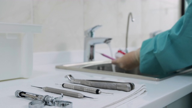 医疗器械背景下医生洗手的牙科工具视频素材