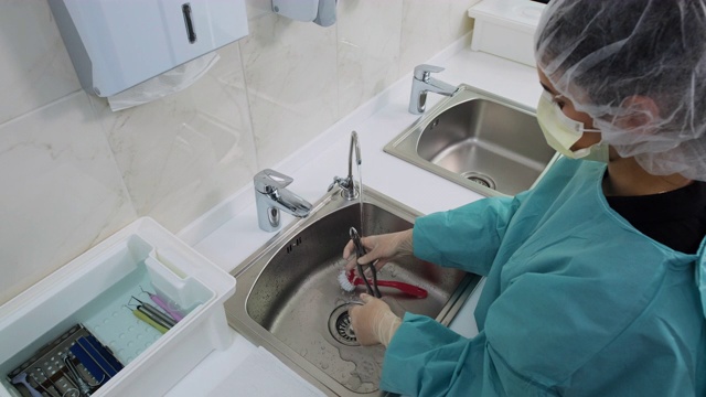 技术员在蒸馏水下清洗牙科工具的宽镜头视频素材