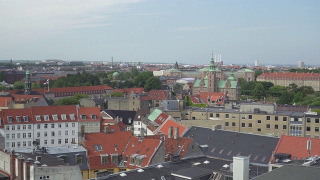 作为著名的旅游目的地之一的圆塔屋顶上的高角度平移视角，可以在下午看到哥本哈根城市的城市景观，丹麦，北欧国家之一。视频下载
