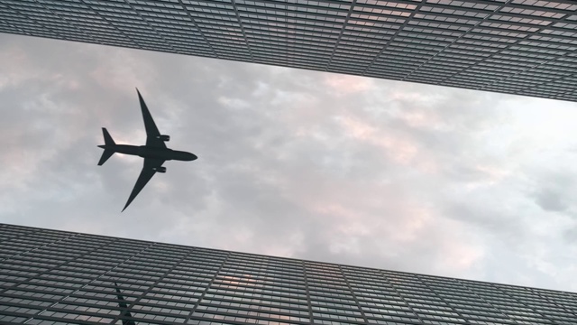 飞机在美丽的天空下飞过办公大楼视频下载
