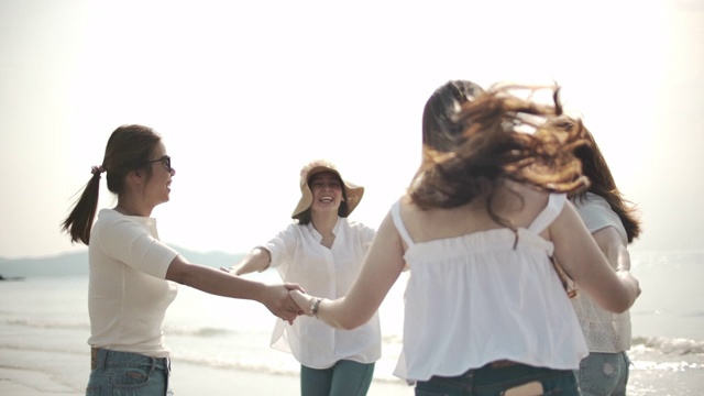 一群亚洲女性朋友在海滩上玩得开心视频素材