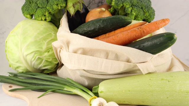 新鲜有机蔬菜放在砧板上和购物袋里视频素材