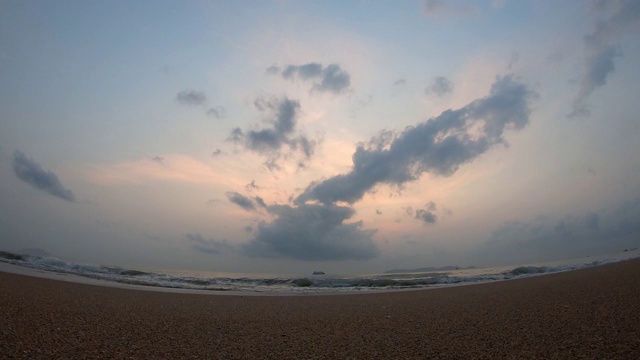 时间流逝的运动，海浪击中海滩和船背景云移动快，金色的光日出在早晨的天空视频下载