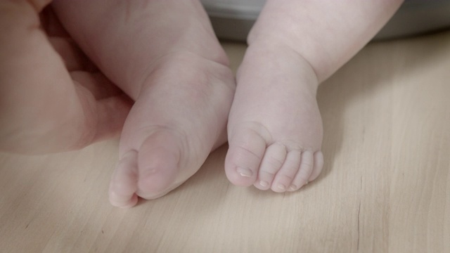 靠近可爱的婴儿蹒跚学步的脚在婴儿卧室与父亲的手触摸视频素材
