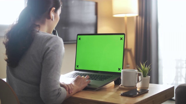 亚洲妇女在家里使用绿色屏幕的笔记本电脑视频素材