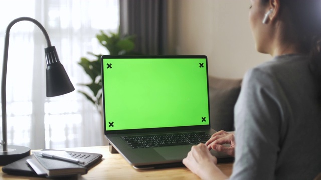 亚洲妇女在家里使用绿色屏幕的笔记本电脑视频素材