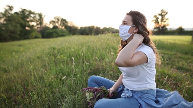 年轻女性戴着防毒面具在隔离室外放松。视频素材