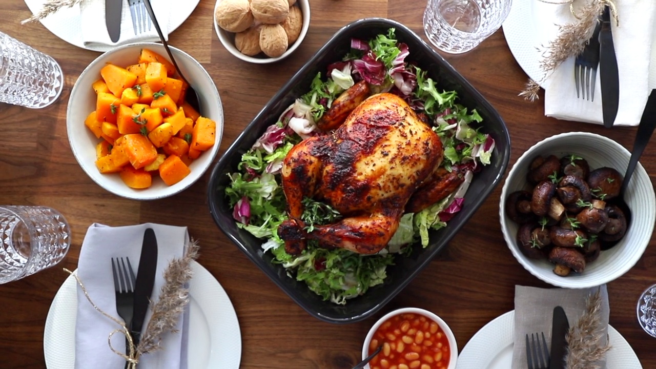 节日餐桌的俯视图，整只烤鸡，南瓜和蘑菇。感恩节或庆祝晚餐的概念视频下载