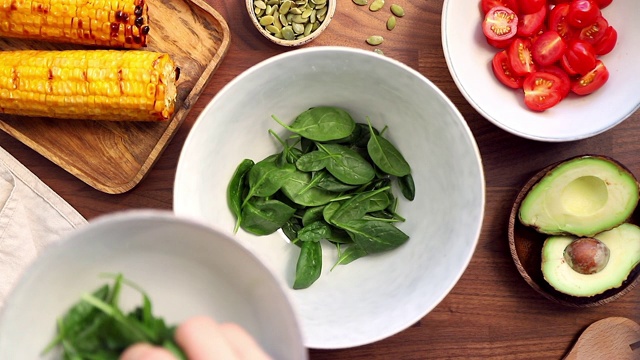 向碗中加入新鲜菠菜。健康饮食理念，用蔬菜制作健康的夏季沙拉。从以上观点。视频下载