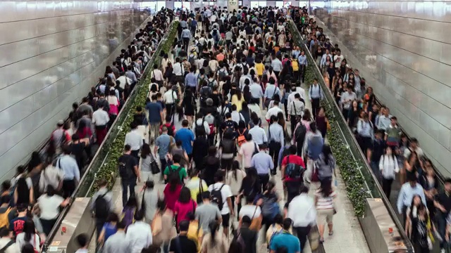 拍摄香港中环地铁站内使用自动扶梯的商业人士和通勤者视频素材