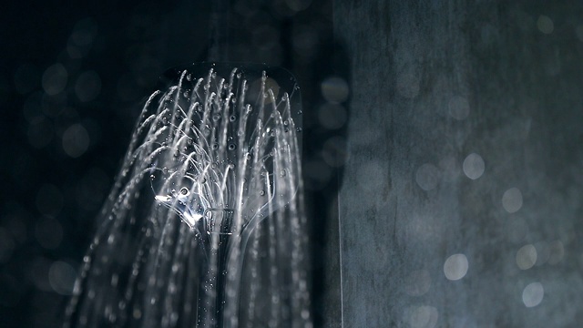 墙壁黝黑的浴室里，从淋浴间落下的水视频下载